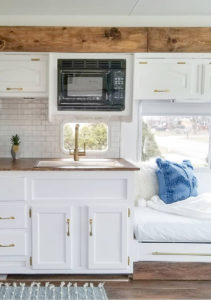 Tour this remodeled RV filled with lots of white, shiplap, and warm wood tones from @WilsonGrandAdventures! Featured on MountainModernLife.com