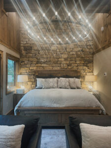 stone accent wall in mountain home bedroom
